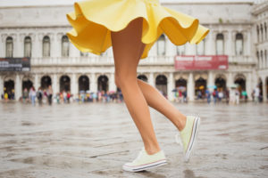 Young woman with sexy legs and yellow skirt